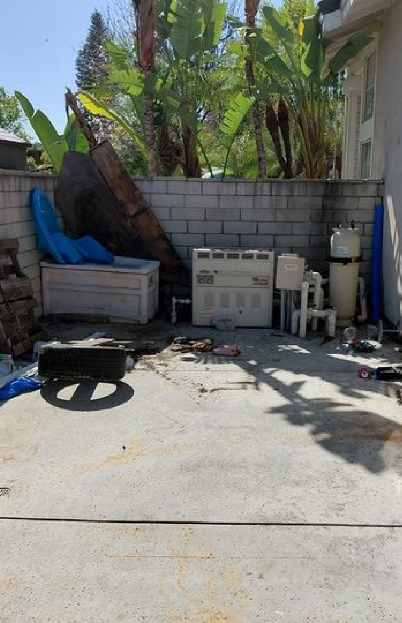 Before junk removal by Rabbits Services, showcasing cluttered yard with old furniture and debris in need of removal