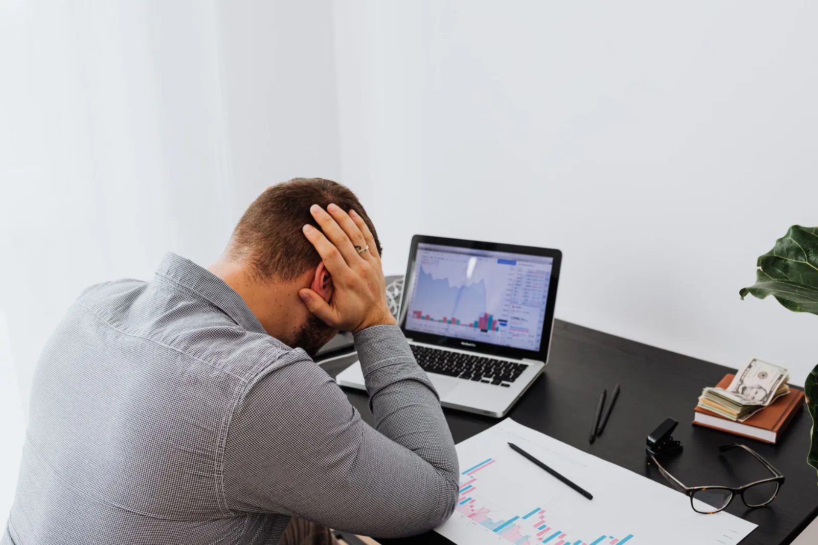 A man at his desk with his head in his hands