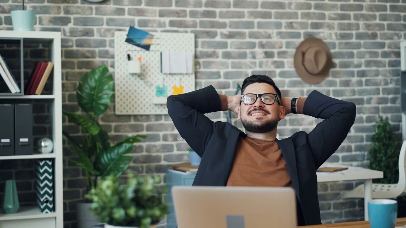 A relaxed business owner leaning back at his desk