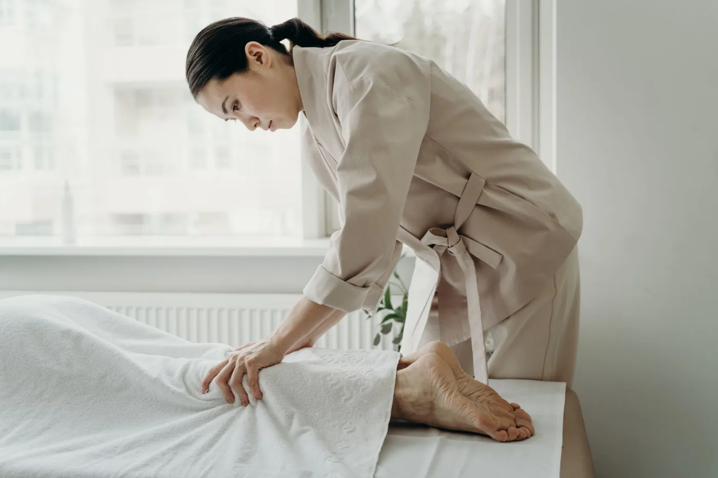 A massage therapist preparing a treatment table