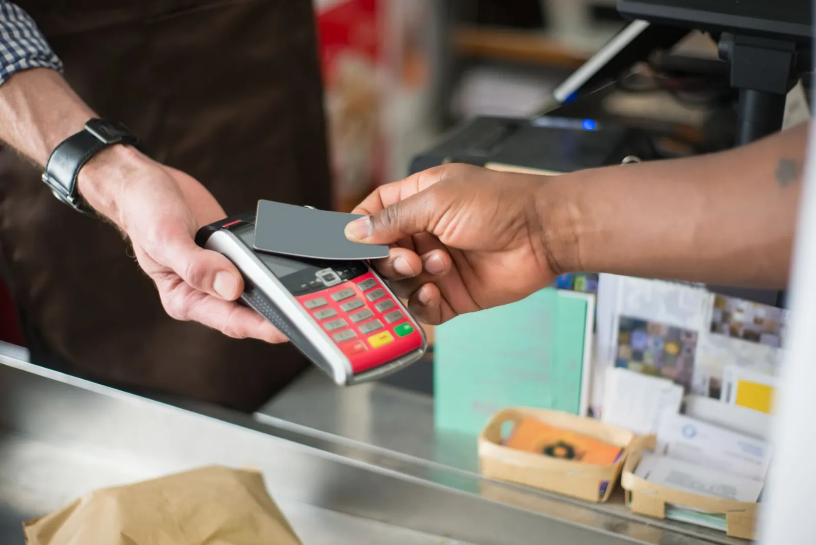 A customer paying by card at a shop counter