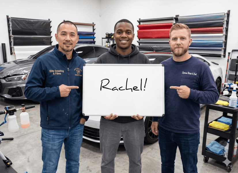 The team holding a whiteboard that says Rachel