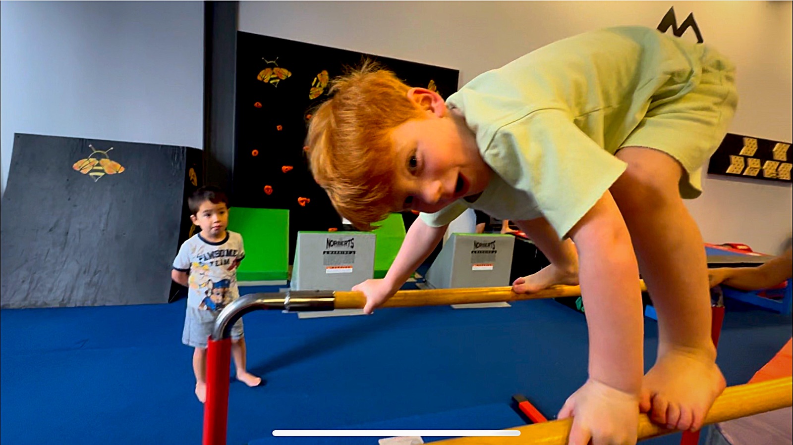 Young camper balancing on parallel bars