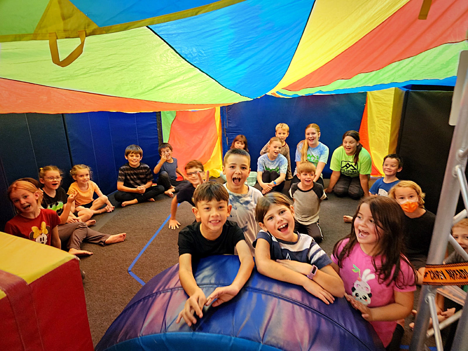 Campers under a rainbow parachute