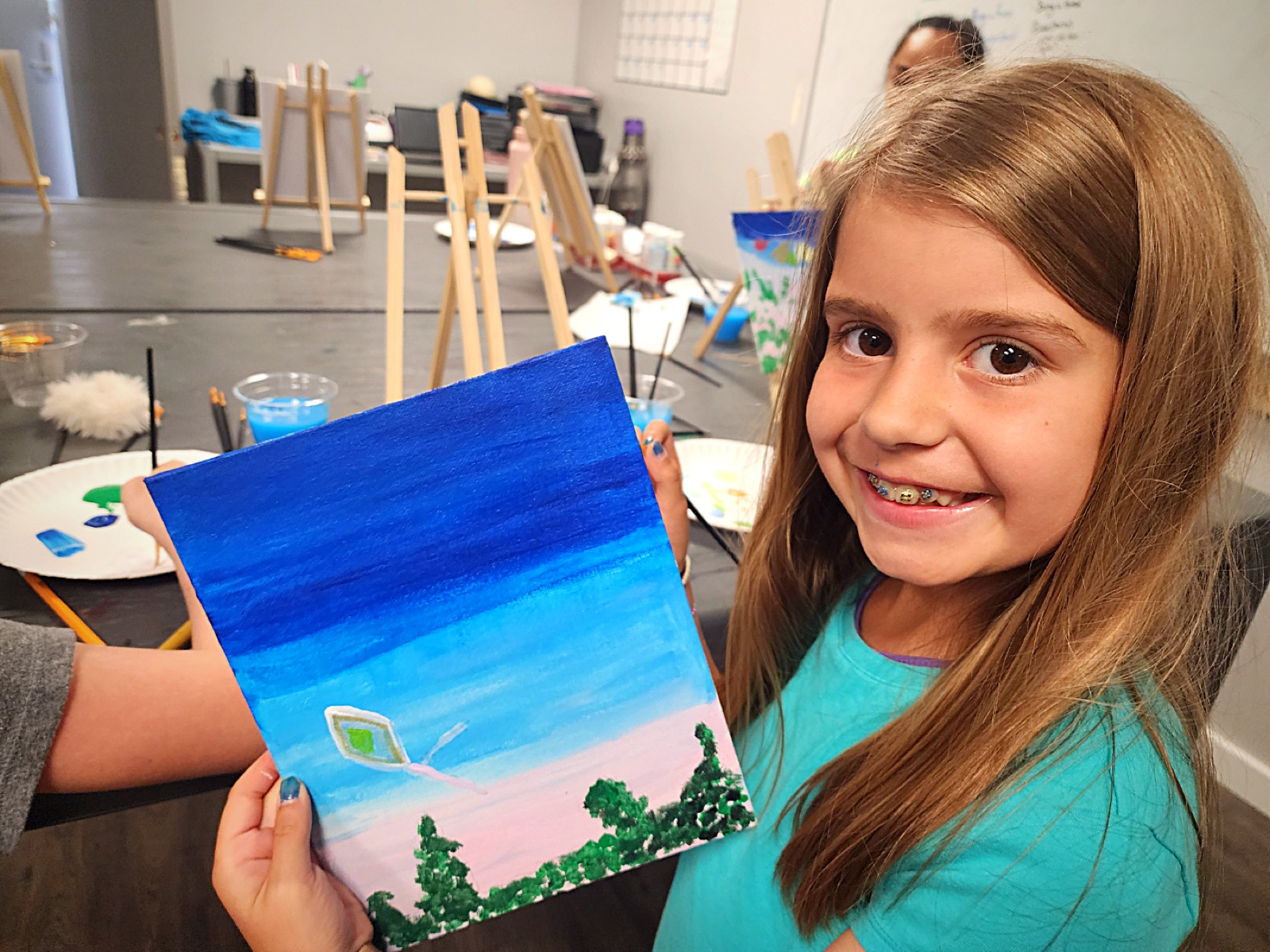 Camper showing off her sky and kite painting
