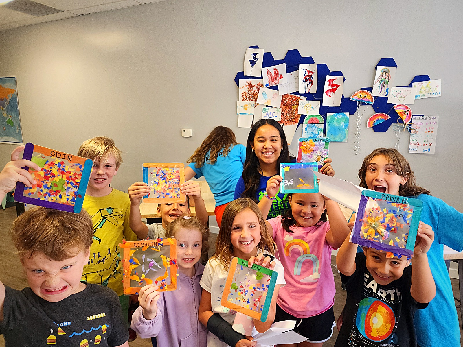 Campers proudly holding up their colorful artwork
