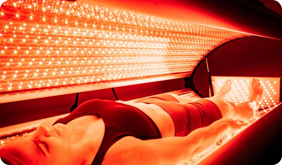 Client lying in red light therapy bed