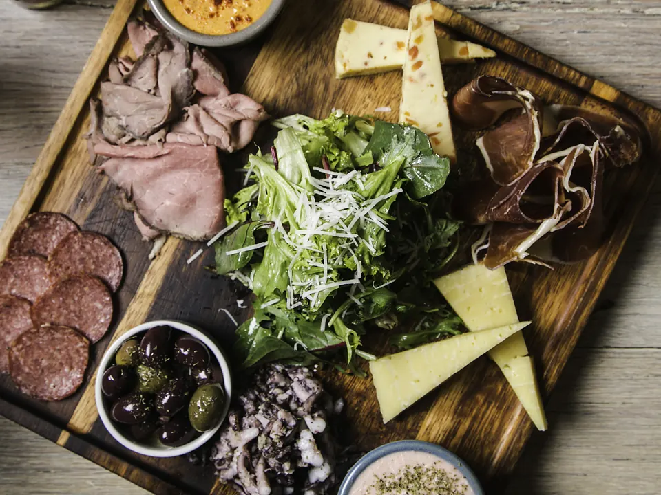 A mezze and charcuterie board with olives, cheese, cured meats and dips