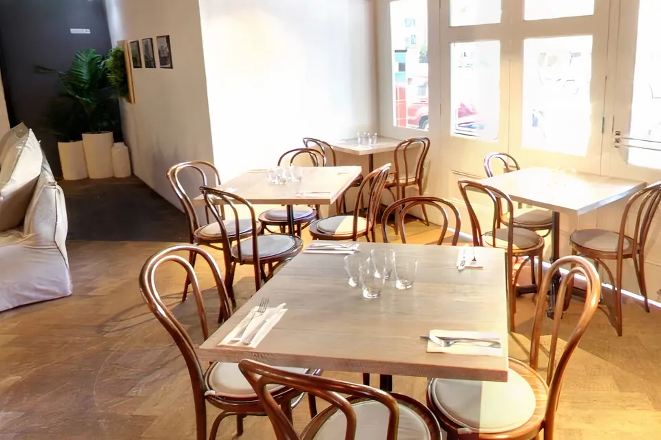 Set tables and bentwood chairs by the windows in The Nest at The Phoenix