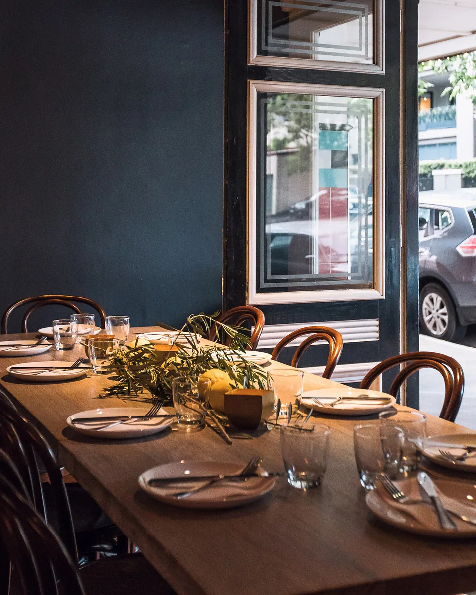 A long function table set with glassware by the open front door of The Phoenix
