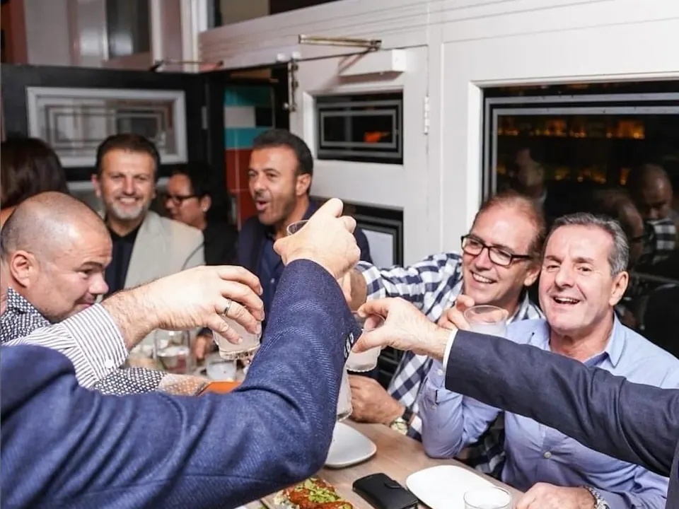 Guests raising shot glasses in a toast at a Greek Night