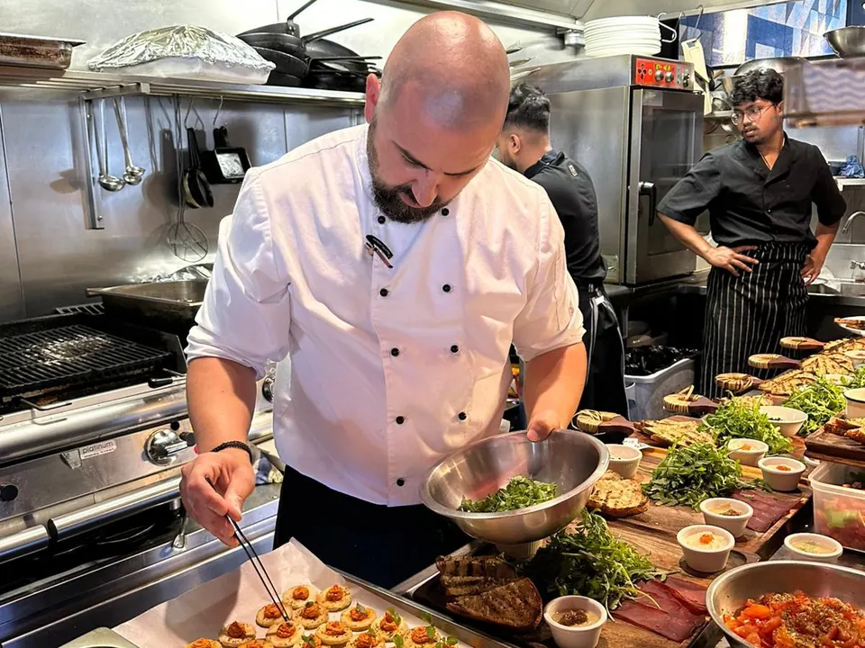 A chef plating trays of canapés in The Phoenix kitchen