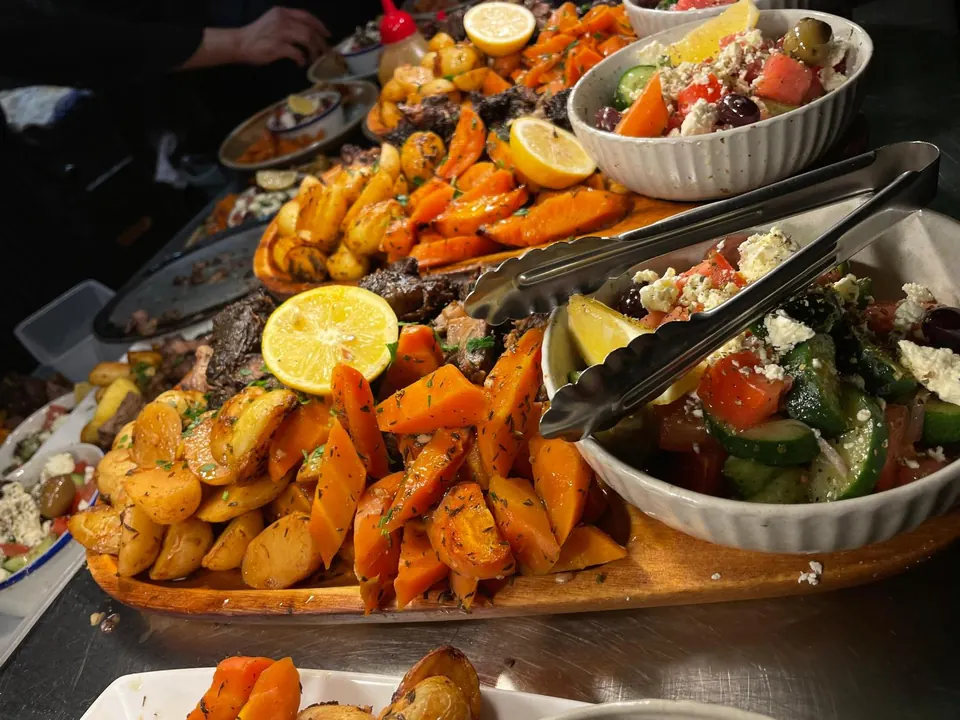 Greek banquet platters of roast potatoes, pumpkin and salads ready for a function