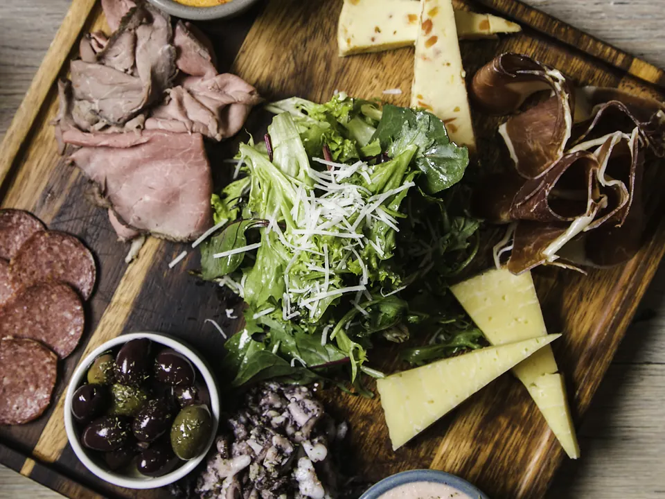 A Greek mezze board of cured meats, cheeses, olives, salad and dips