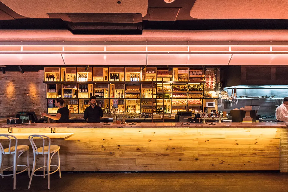 The Main Bar with its long marble counter under customisable pink over-bar lighting