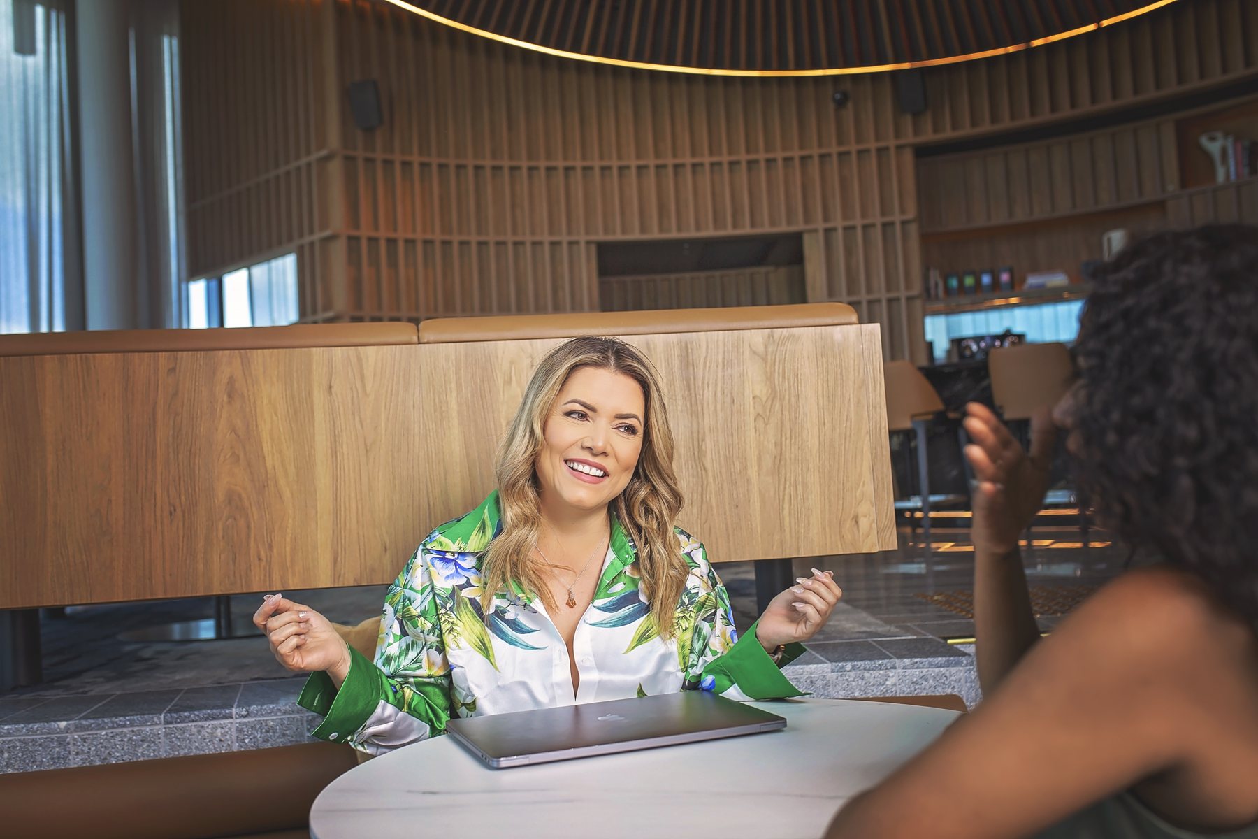 Julia Mann, founder of JulAi, smiling at her laptop in Brisbane