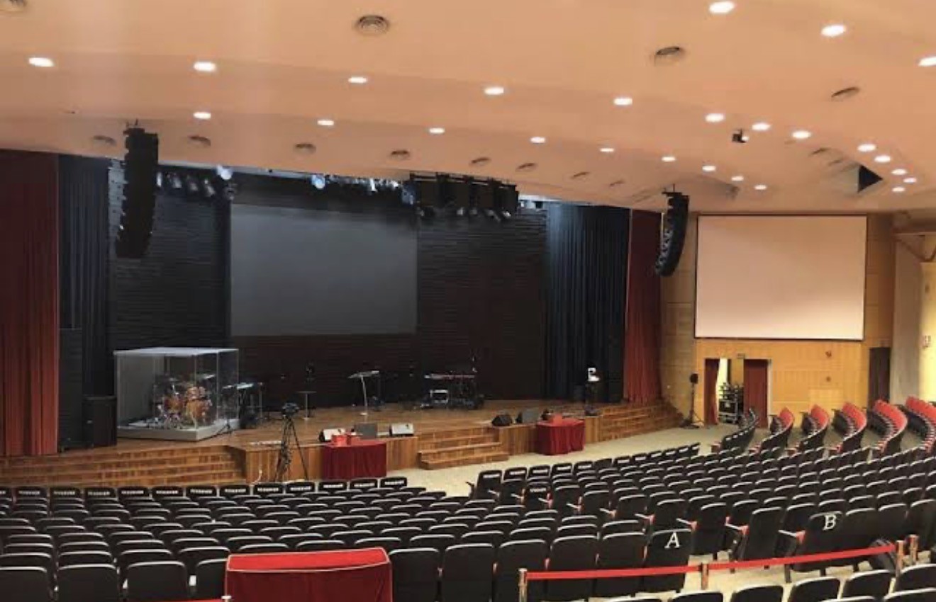 Church sanctuary with a stage and line array loudspeakers hung on both sides