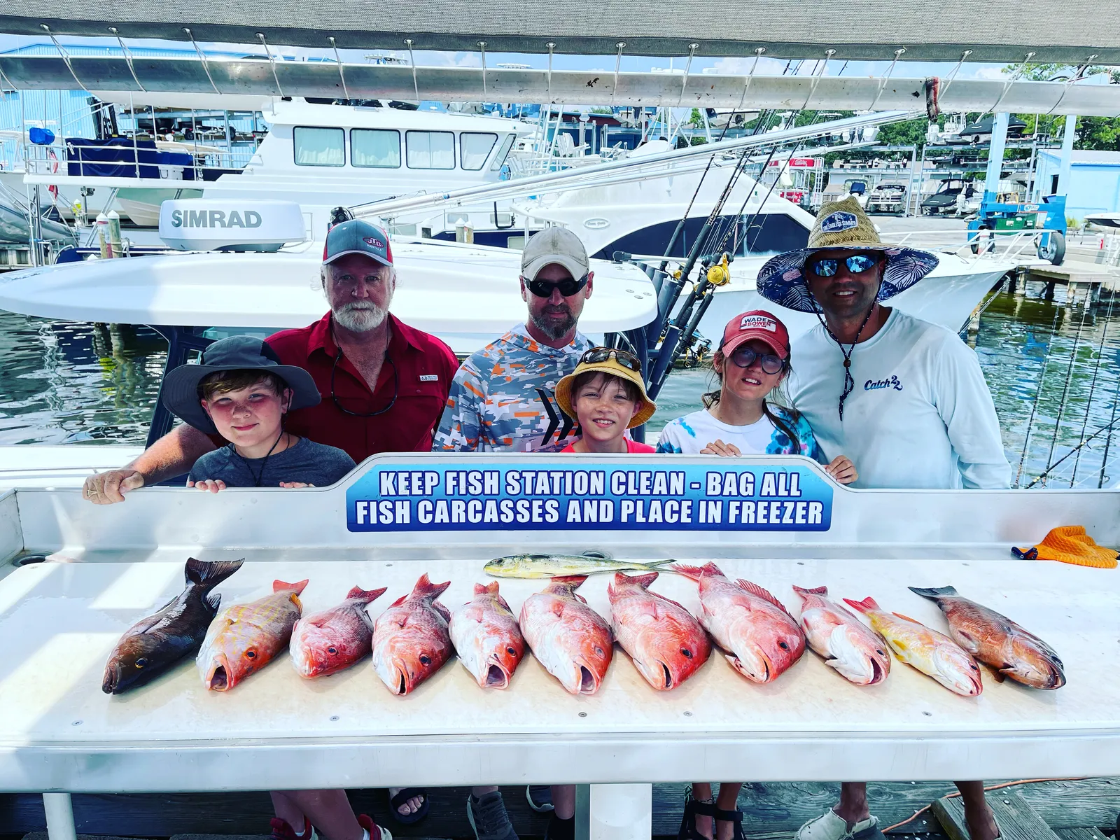 Family holding a trophy red snapper on the deck of Catch 22 in Destin, FL