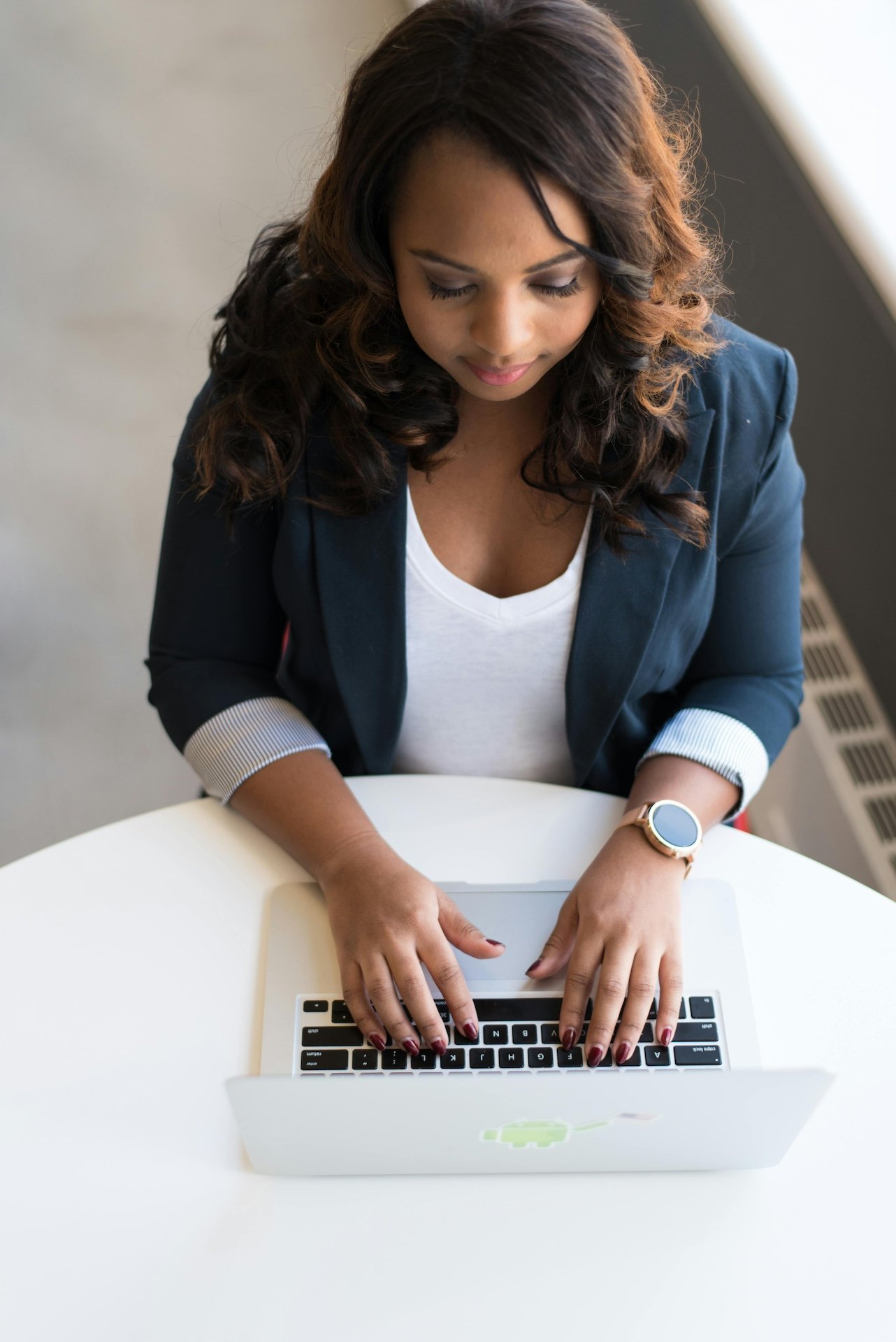 Professional in a navy blazer working on a laptop