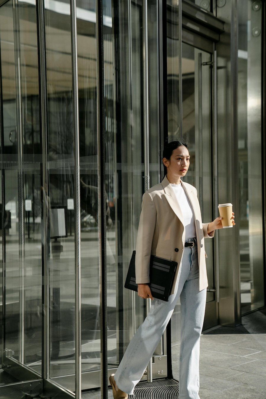 Young professional in a blazer walking out of an office building