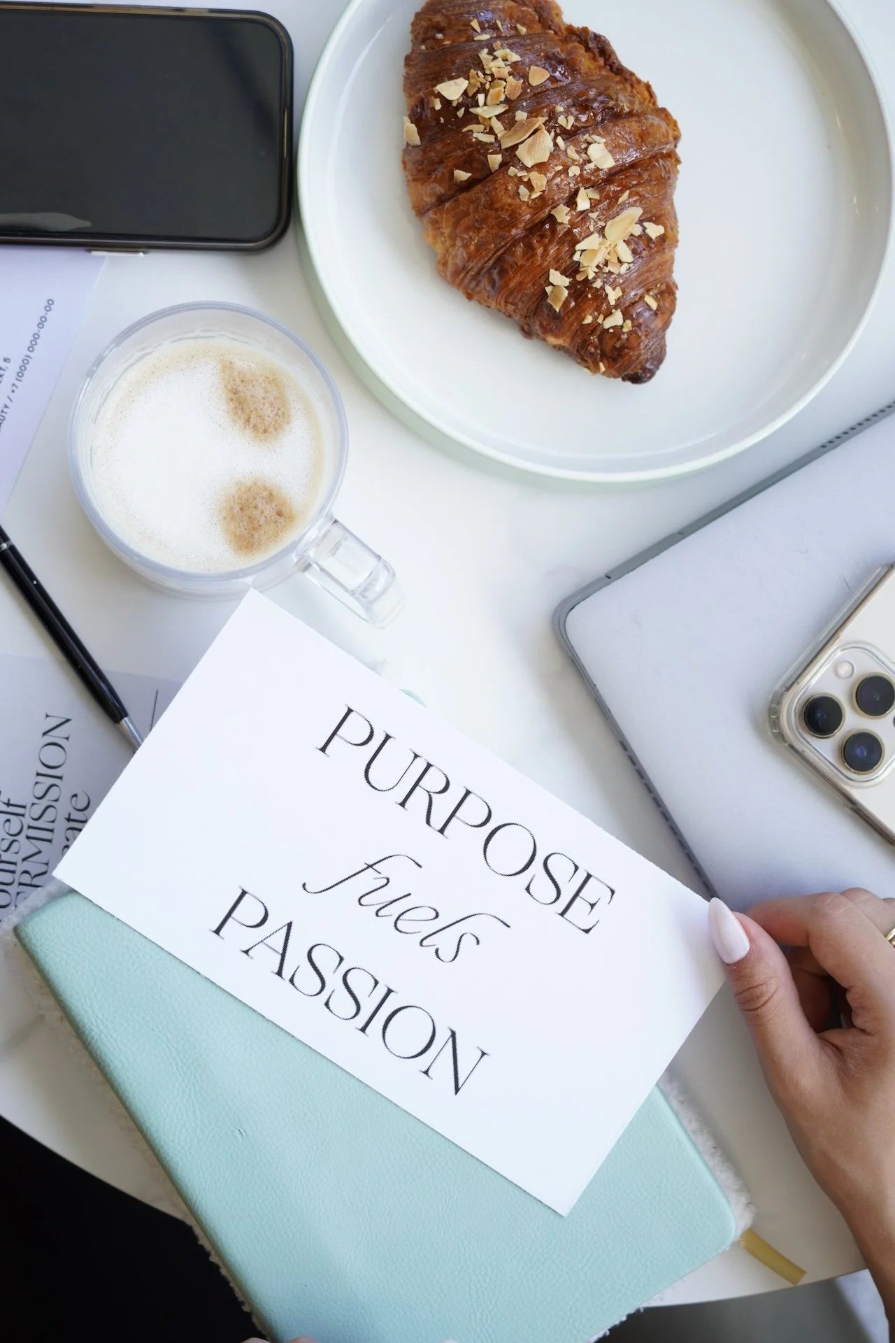 Coffee, a croissant and a card that reads Purpose fuels passion