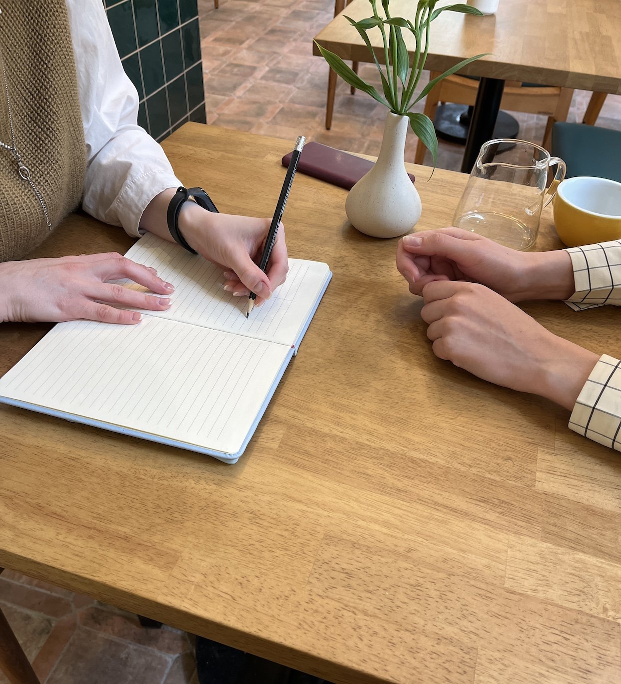 Coach and client taking notes together at a wooden table