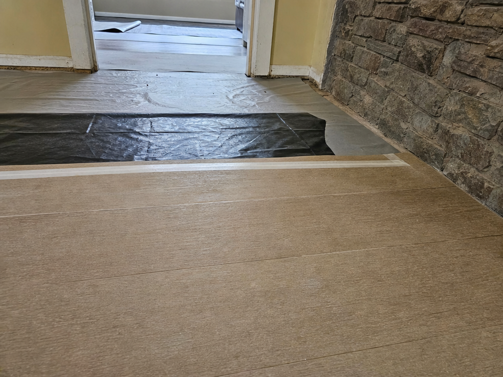 Level prepped subfloor with underlayment and moisture barrier