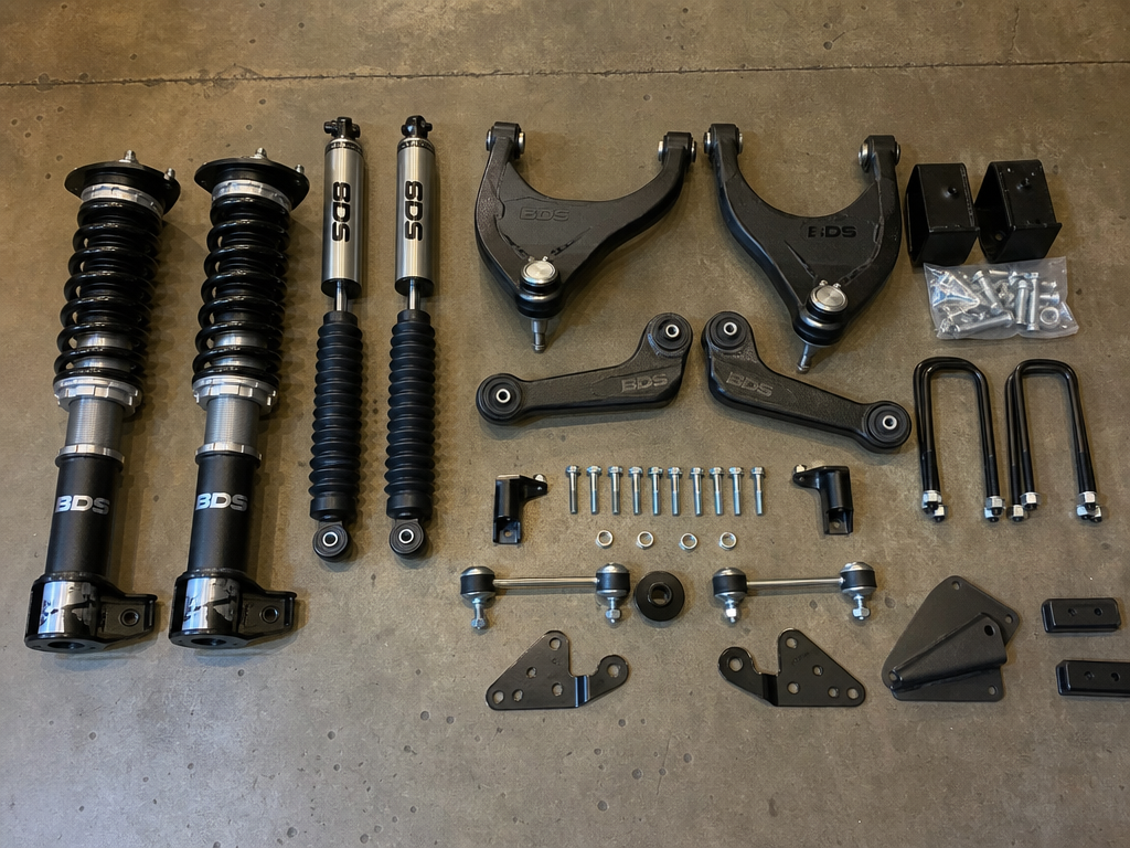 Short arm suspension lift kit components laid out on shop floor at Iron Ridge Off-Road Houston