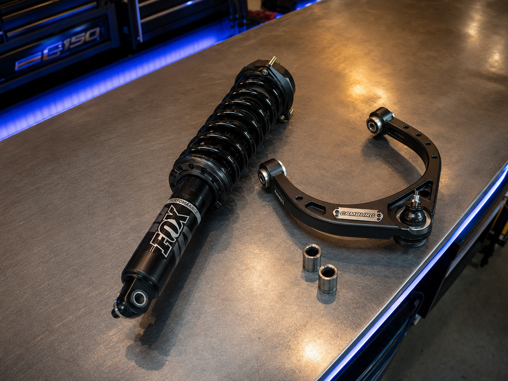 Ford F-150 front suspension on a shop hoist with coilover and control arm visible
