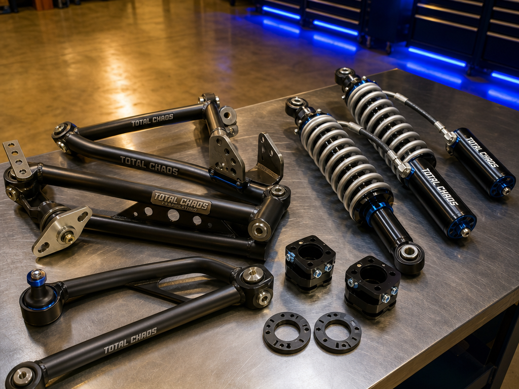 Long-travel control arms and bypass coilovers laid out before install
