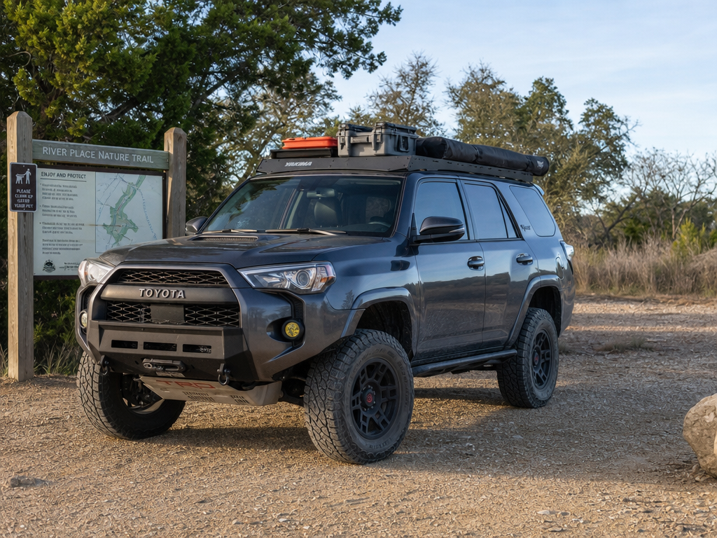 Lifted Toyota 4Runner loaded for overlanding at a Texas trailhead