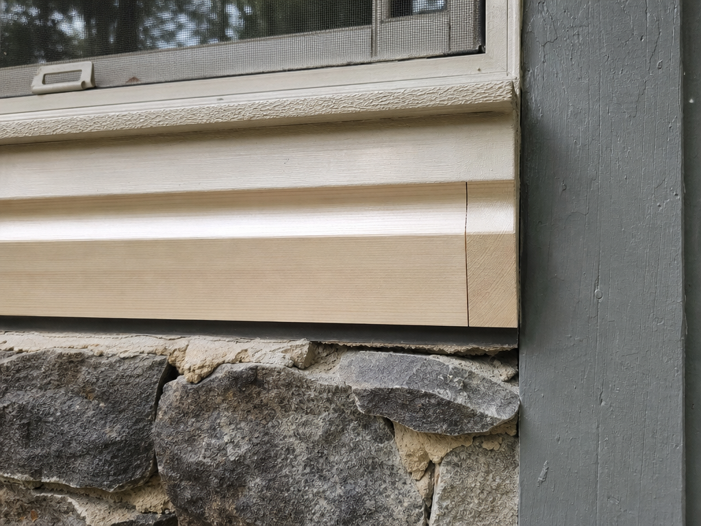 Clean new wood repair blended into existing trim with tight joints
