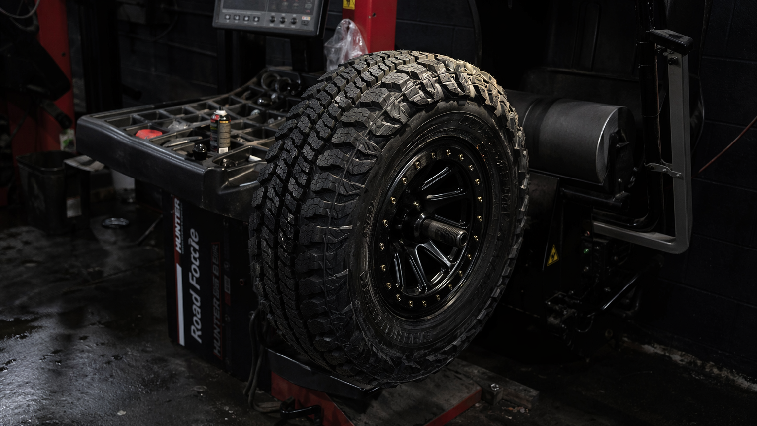 Mud terrain tire freshly mounted on beadlock wheel on balancing machine