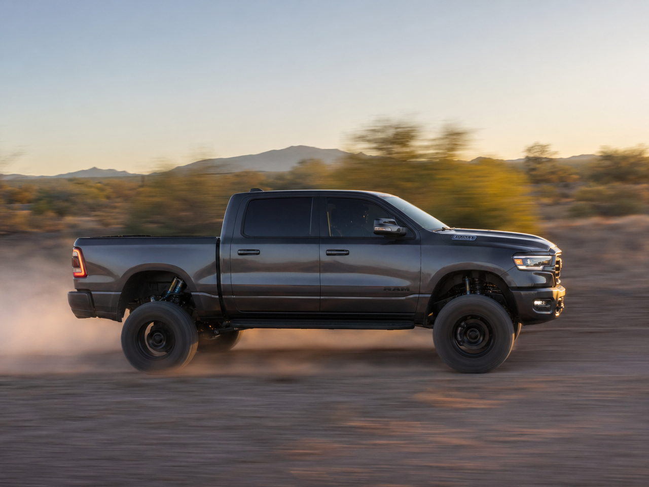 Lifted truck at speed on dirt road body flat and level through rough terrain