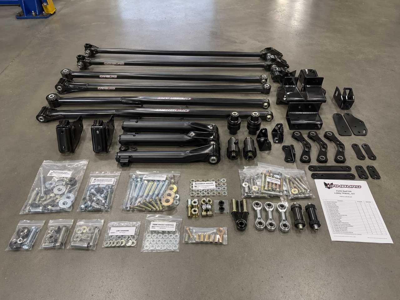 Complete long arm suspension kit laid out on shop floor before installation