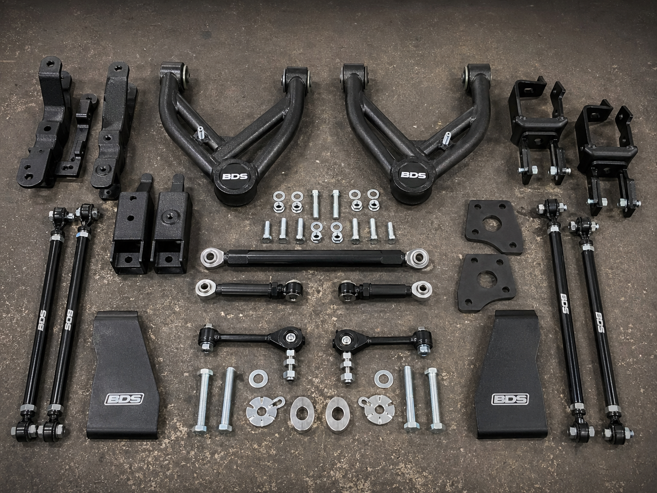 Geometry correction components including upper control arms drop brackets and end links laid out as a complete proper lift kit