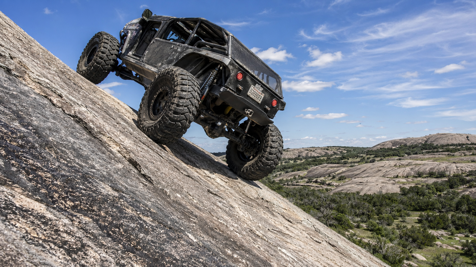 Purpose built rock crawling Jeep at steep angle on Precambrian granite dome in Texas Hill Country