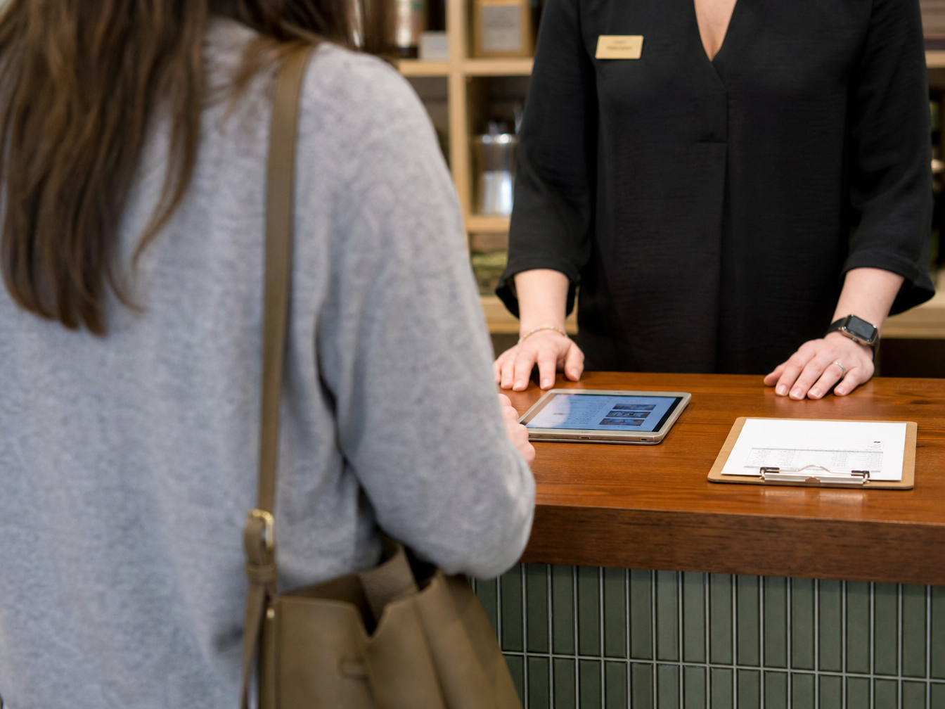 Two shop owners in conversation across a service counter
