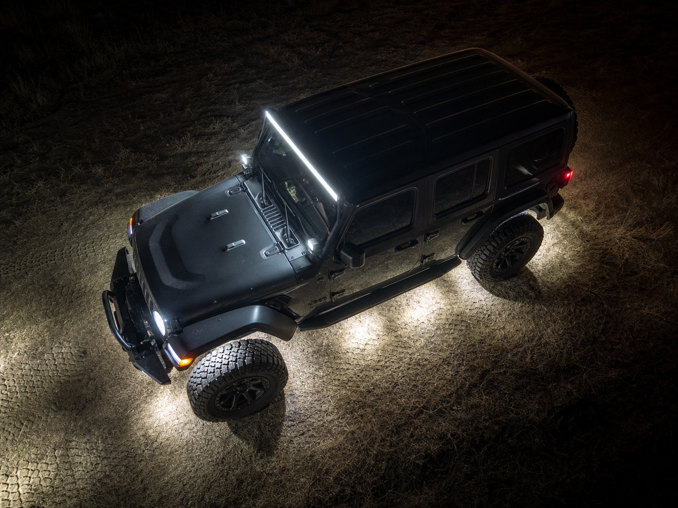 Jeep Wrangler with A-pillar pods and LED bar on trail at night