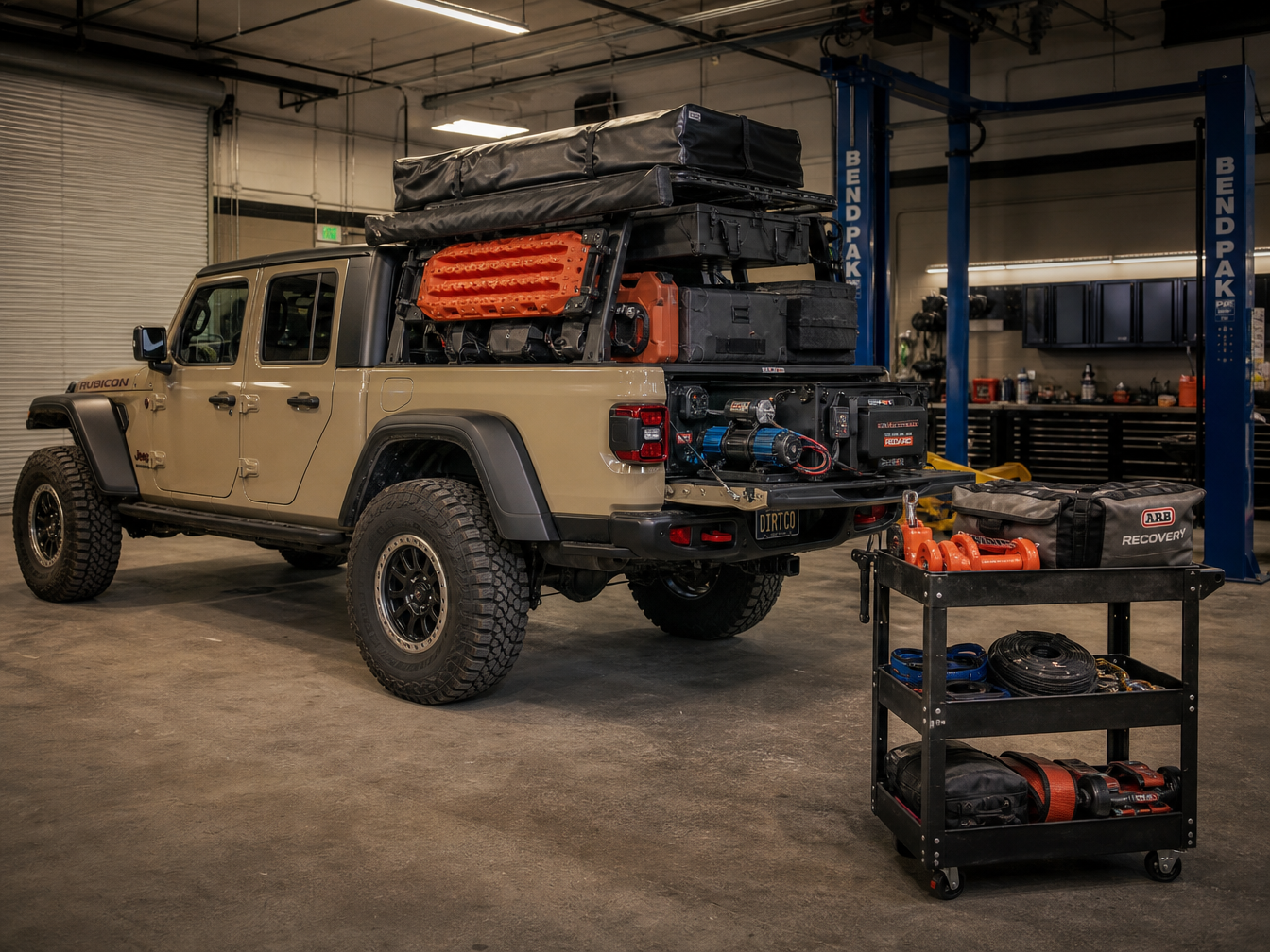 Gladiator JT overland build with bed-mounted gear storage and ARB dual compressor setup in professional shop bay