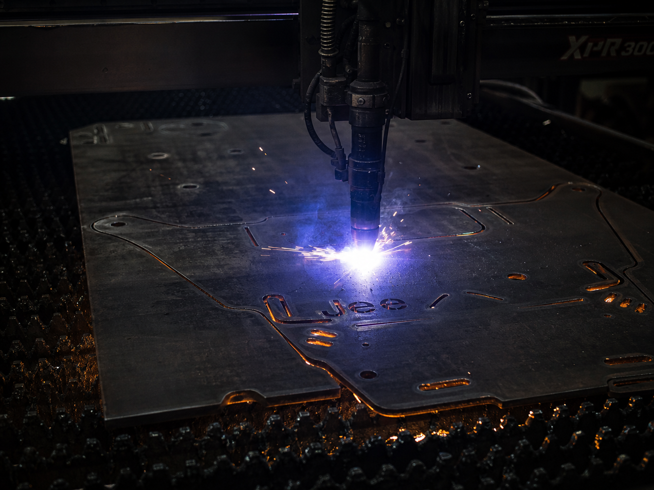 CNC plasma cutting table cutting precision Jeep skid plate shapes from steel plate in Summit Jeep Works fabrication shop