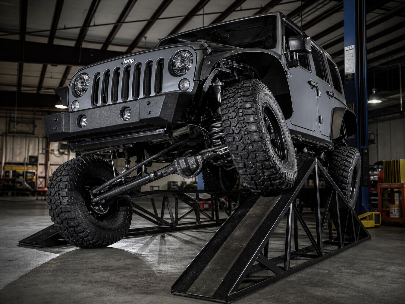 Jeep Wrangler at full suspension articulation on an RTI ramp with one wheel dramatically elevated showing maximum flex
