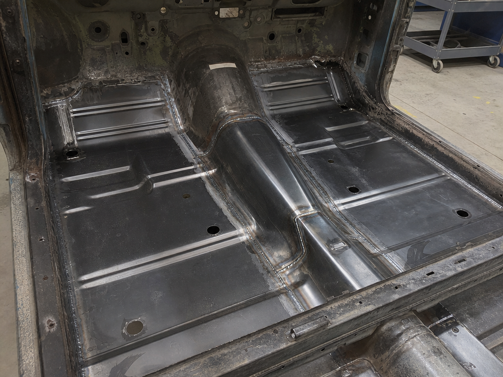 New floor pan welded into a classic car during rust repair