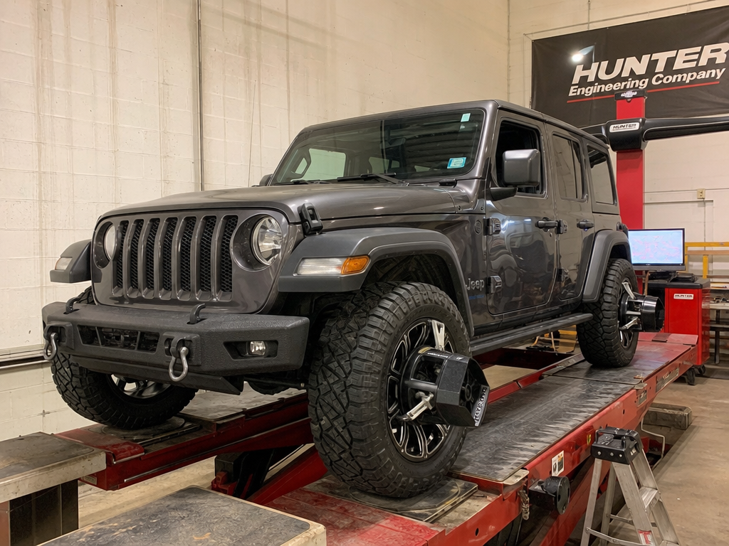 Iron Ridge Off-Road technician performing post-repair alignment on a lifted Jeep in Houston