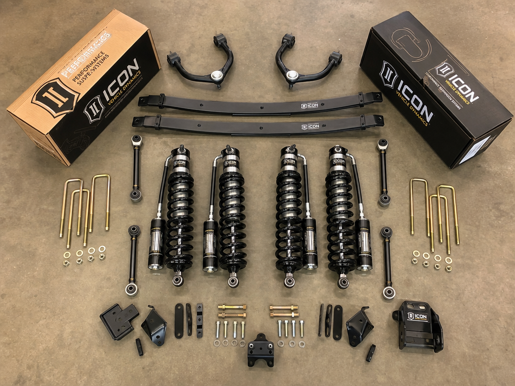 Toyota Tacoma 3-inch lift kit components including coilovers and upper control arms on shop floor