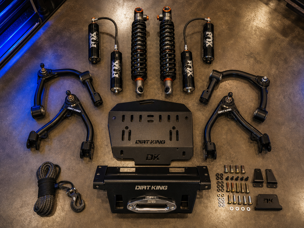 Off-road build accessories and lift components flat-lay — coilovers, control arms, skid plate hardware