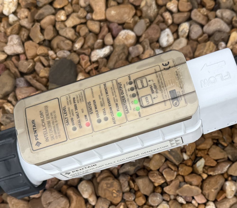 Pentair IntelliChlor salt chlorine generator cell plumbed in line on a Houston pool equipment pad, status panel showing salt level and sanitizer output