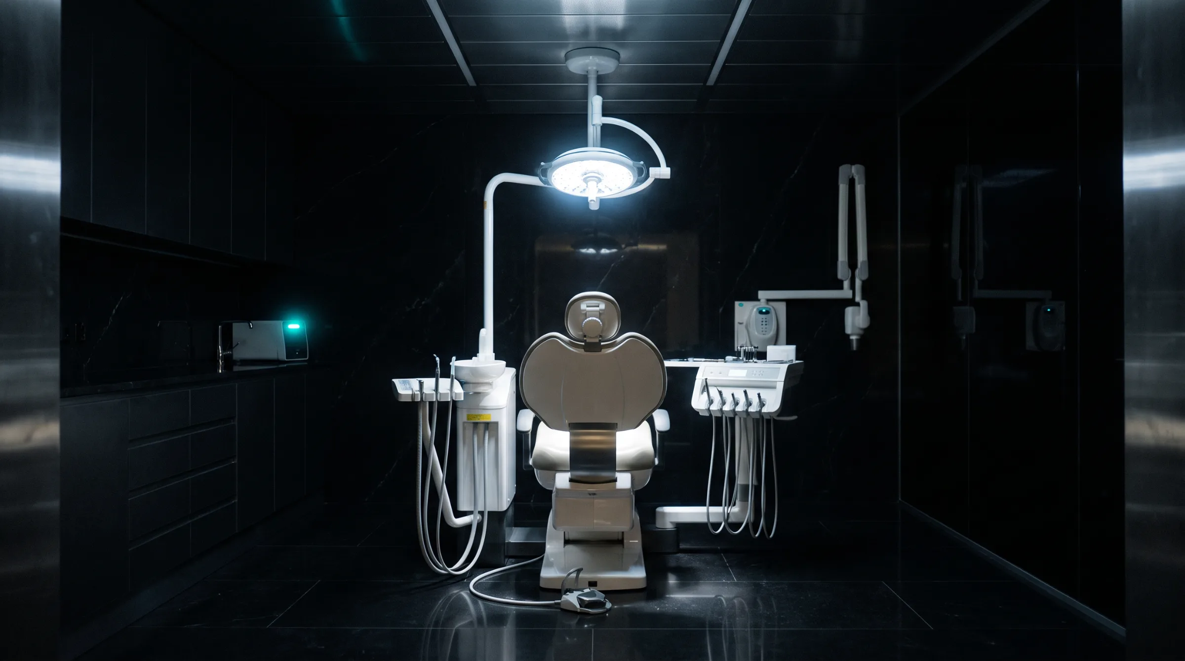 Illustrative image, not a real practice: an empty oral surgery suite at night with one light over the chair