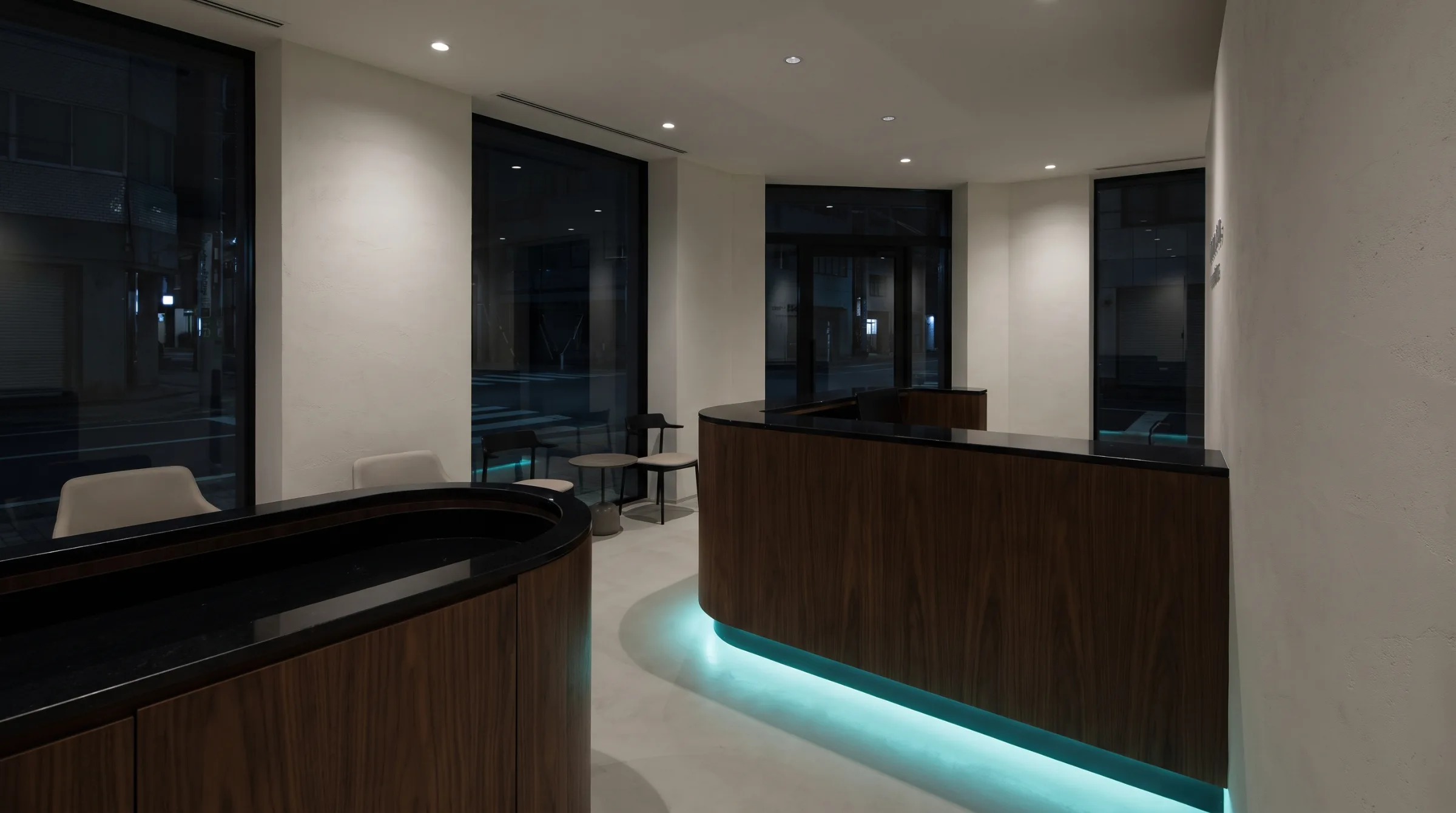 Illustrative image, not a real practice: a dental reception desk at night in walnut and black stone