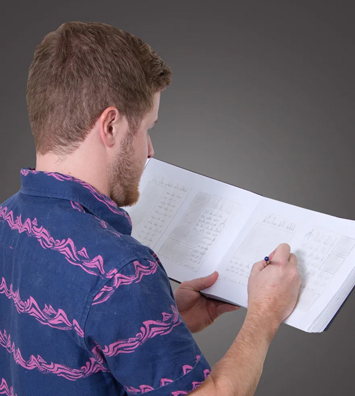 Blake writing notes in an open planning notebook